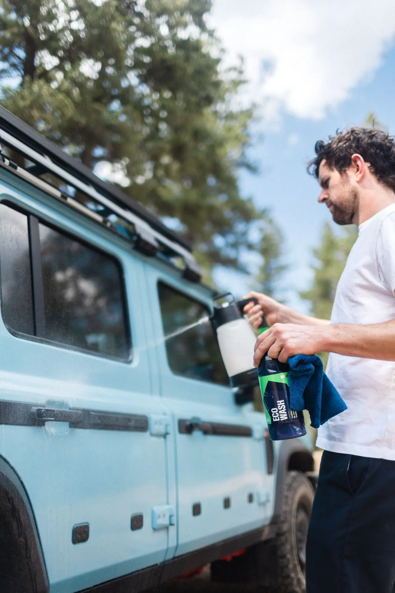 Man met pompspuit, EcoWash-fles en microvezeldoek klaar voor rinseless wash